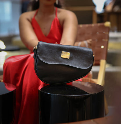 Denri Africa's black Montana Sling Bag. Polished black vegan leather sling, small travel-ready bag.