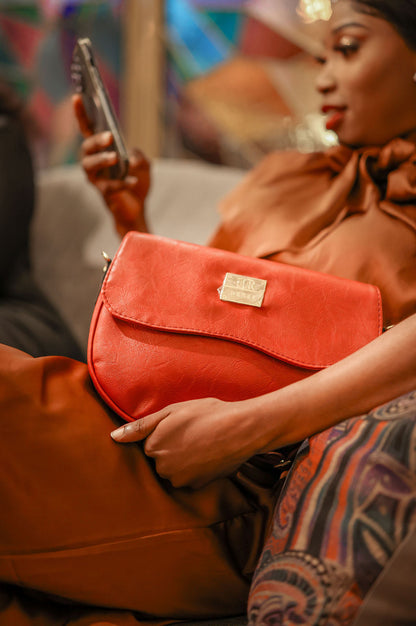 Denri Africa's red Montana Sling Bag. Compact crossbody sling, bold vegan leather design, everyday essentials bag.